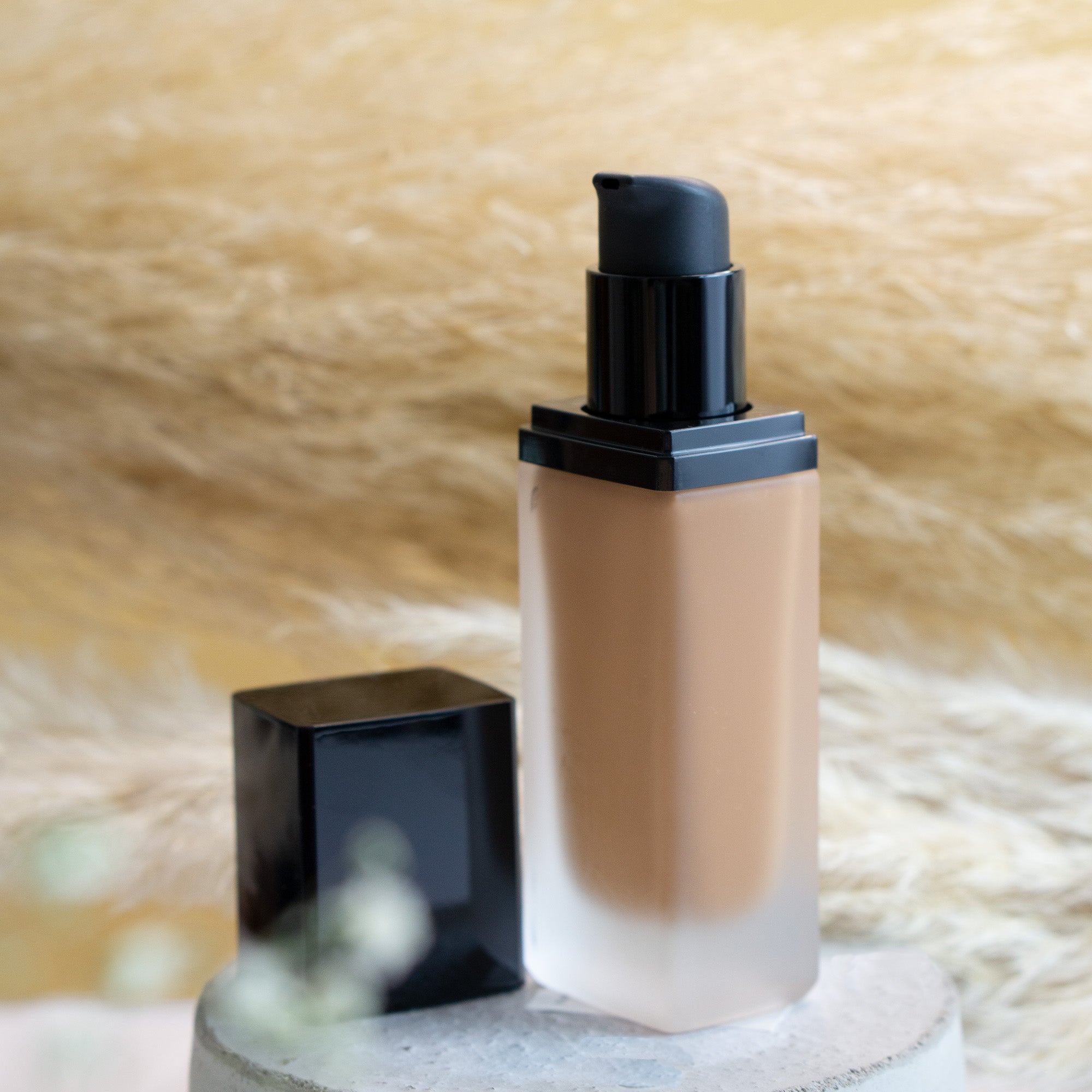 Bronze Night foundation in a frosted glass bottle with a black pump and cap.