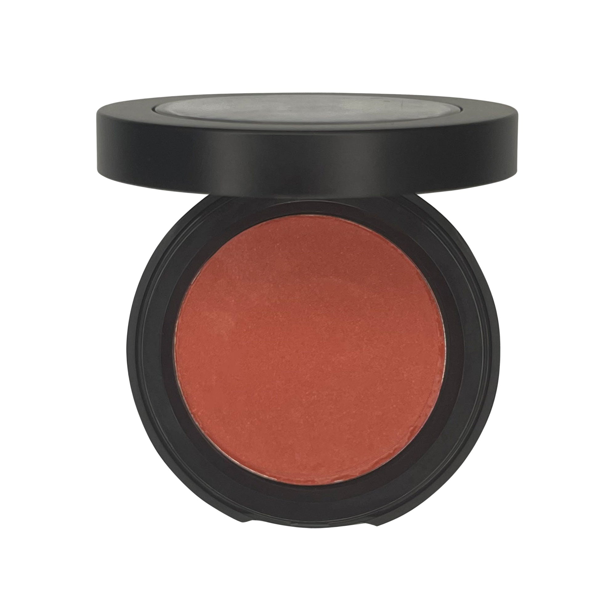 An open black compact with a round pan of matte orange blush.