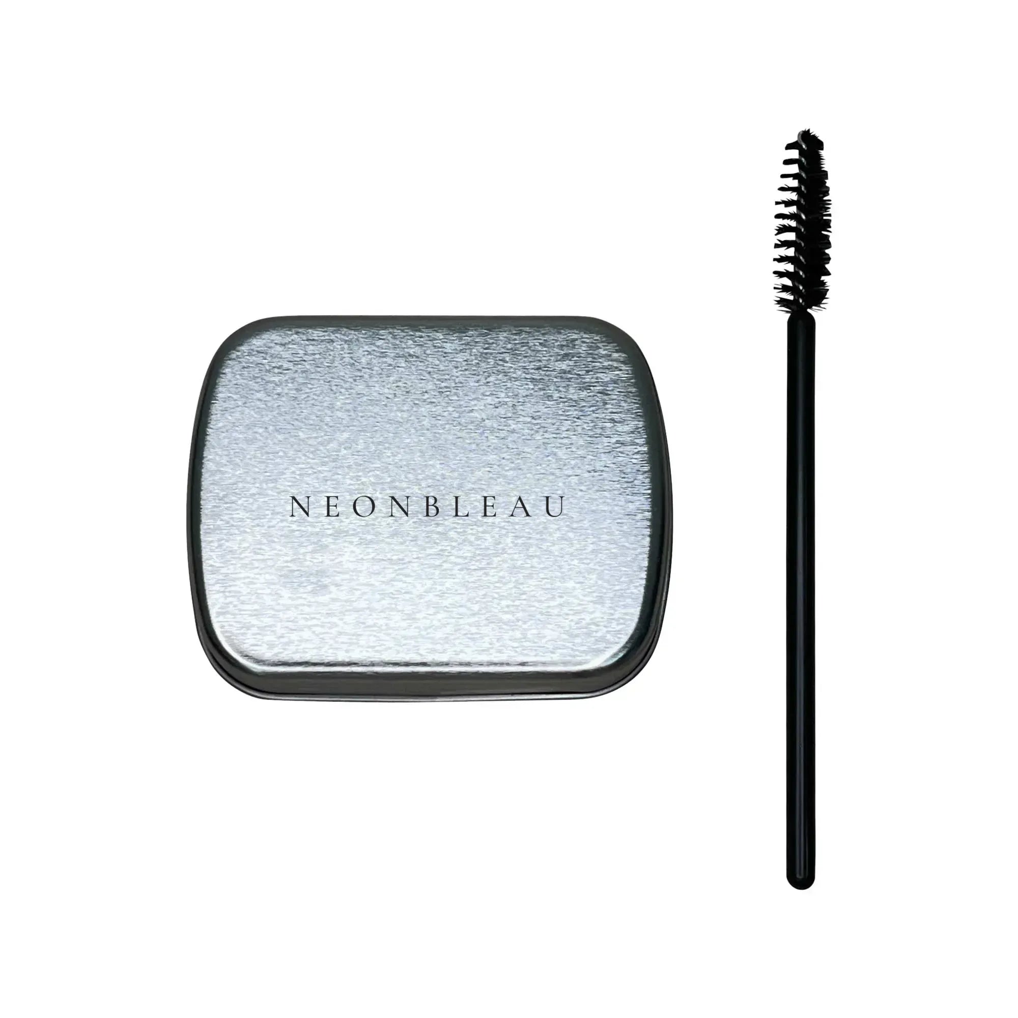 A silver rectangular tin of brow soap with "NEONBLEAU" on top and a black spoolie brush.
