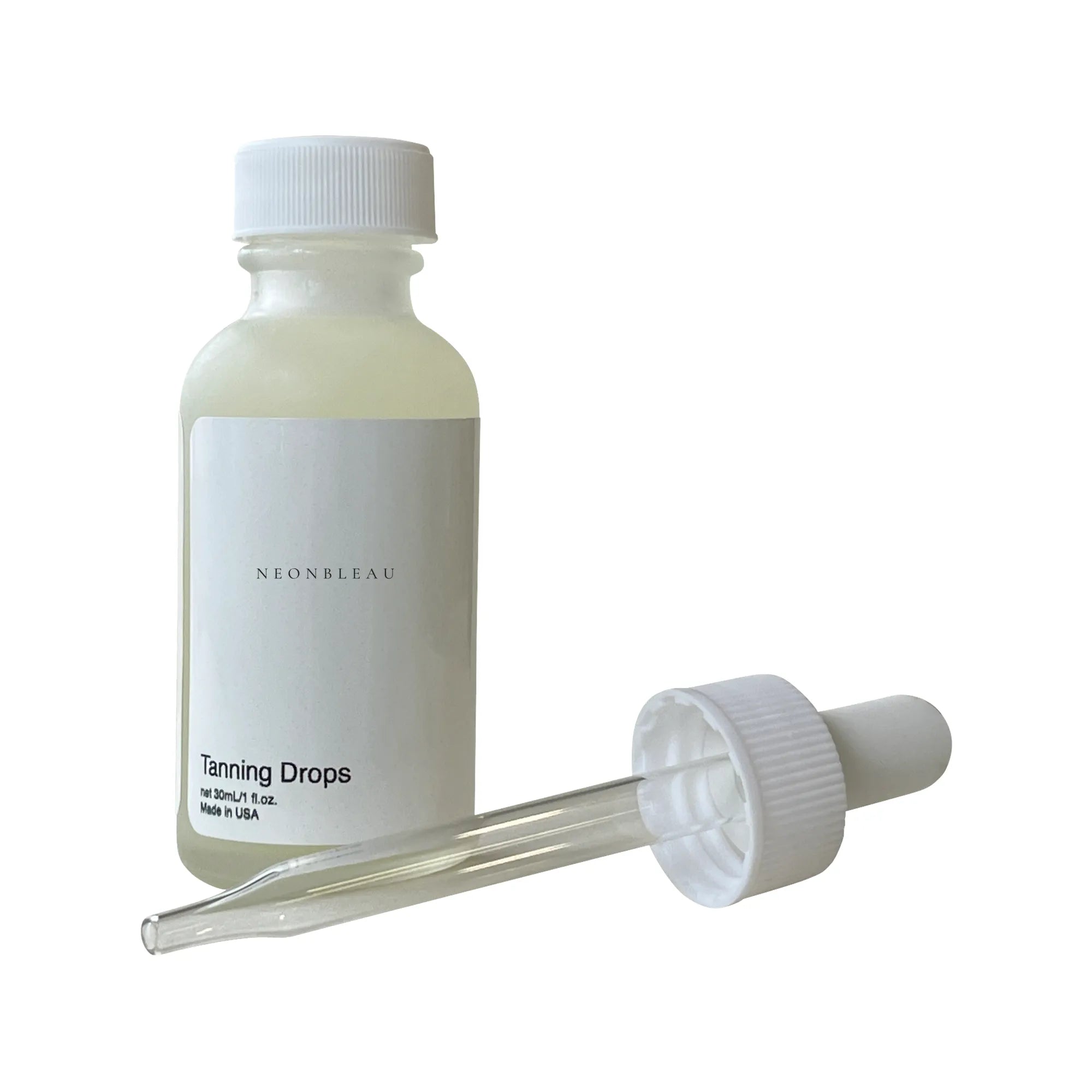 A white bottle of Tanning Drops with a dropper next to it.