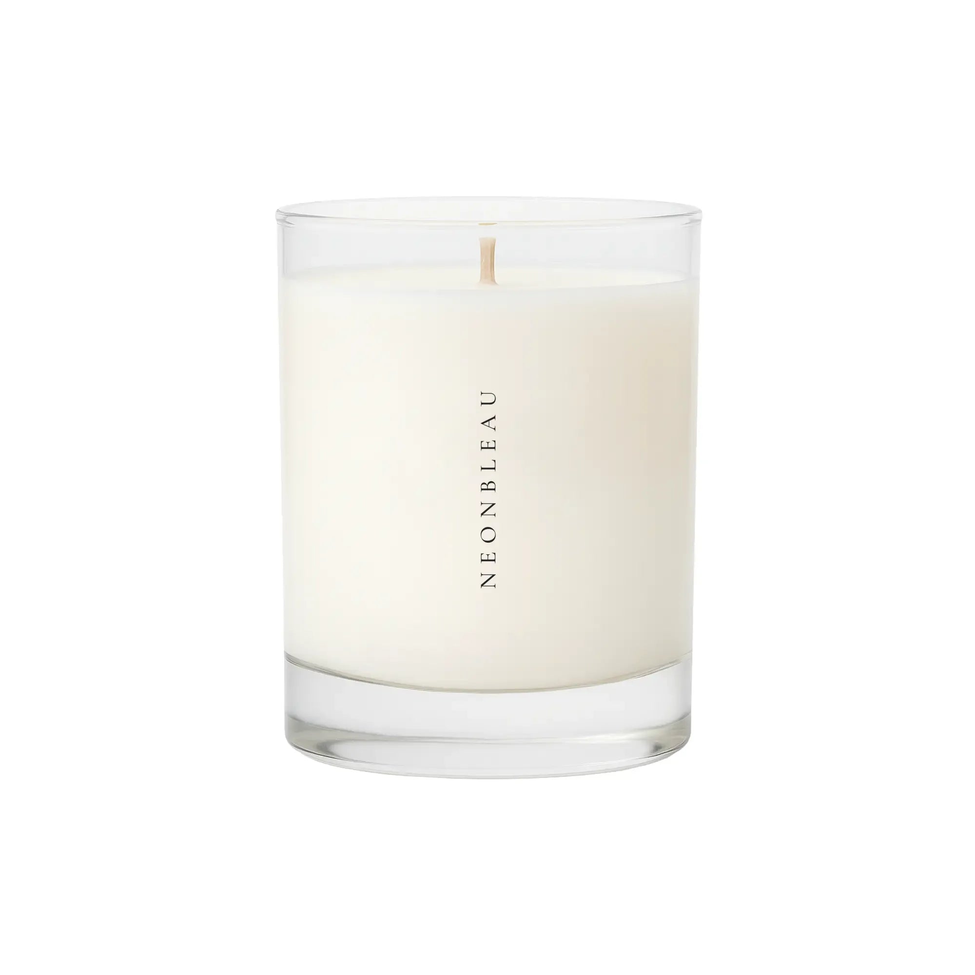 A white scented candle in a clear glass jar with "NEONBLEAU" printed vertically.
