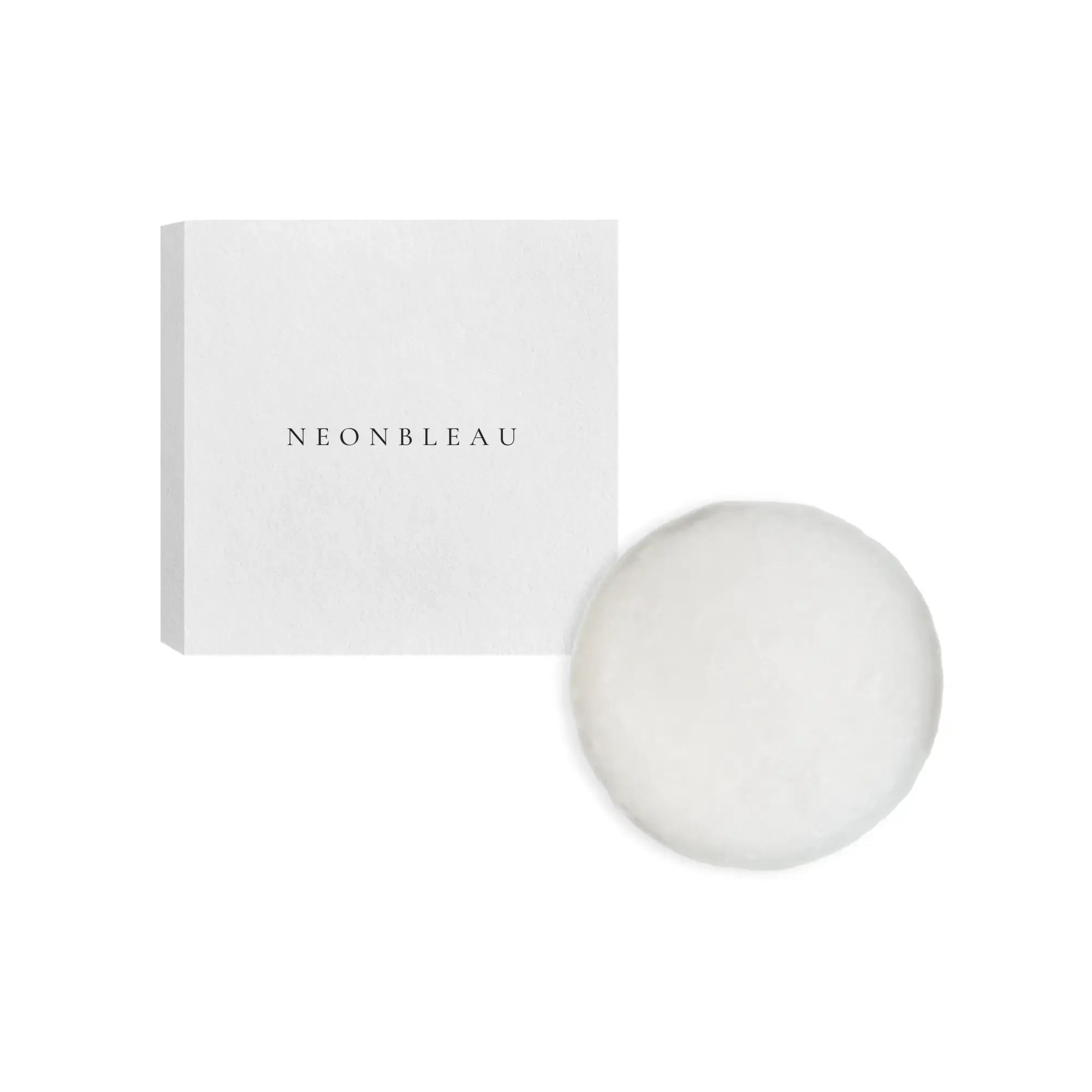 A white rectangular box with "NEONBLEAU" printed on it and a round white shampoo bar.