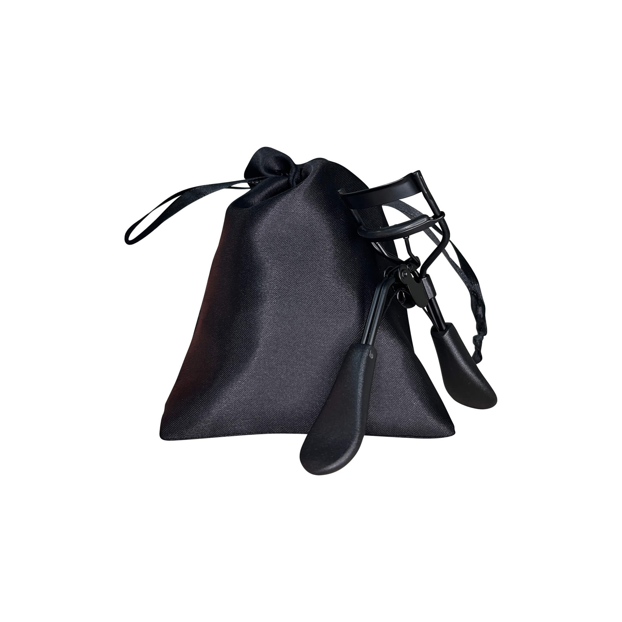 A black padded eyelash curler rests against a black drawstring pouch.