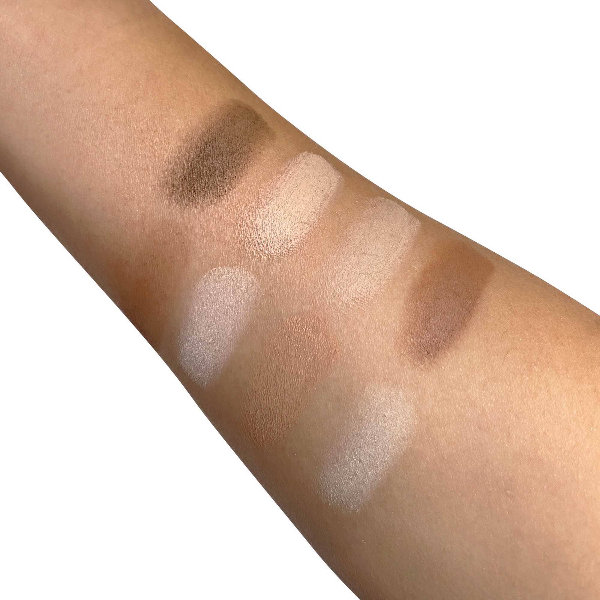 An arm swatched with eight shades of contour and highlight powders.