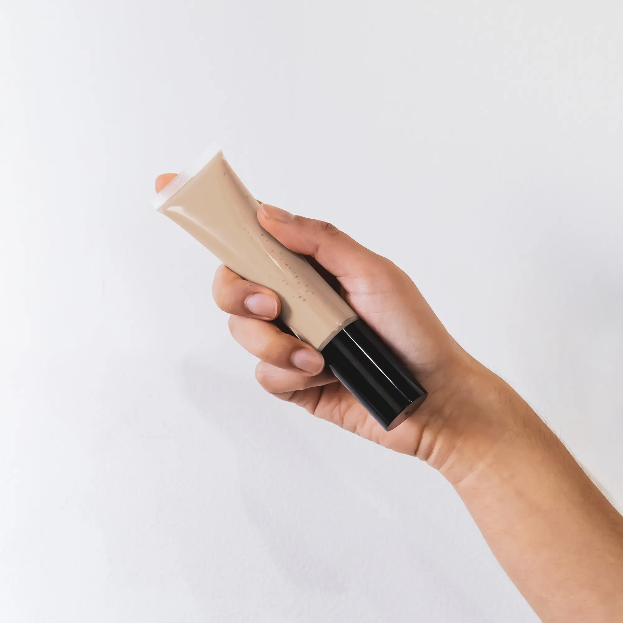 Hand holding a tube of BB Cream in Vanilla shade.