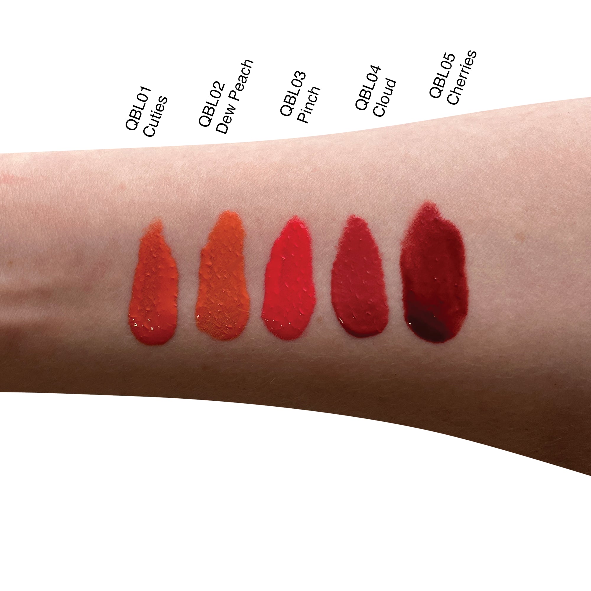 Five swatches of liquid blush in shades of orange and red on an arm.
