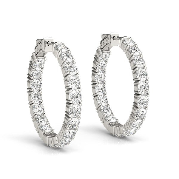 Two 14k white gold hoop earrings with prong-set round diamonds.
