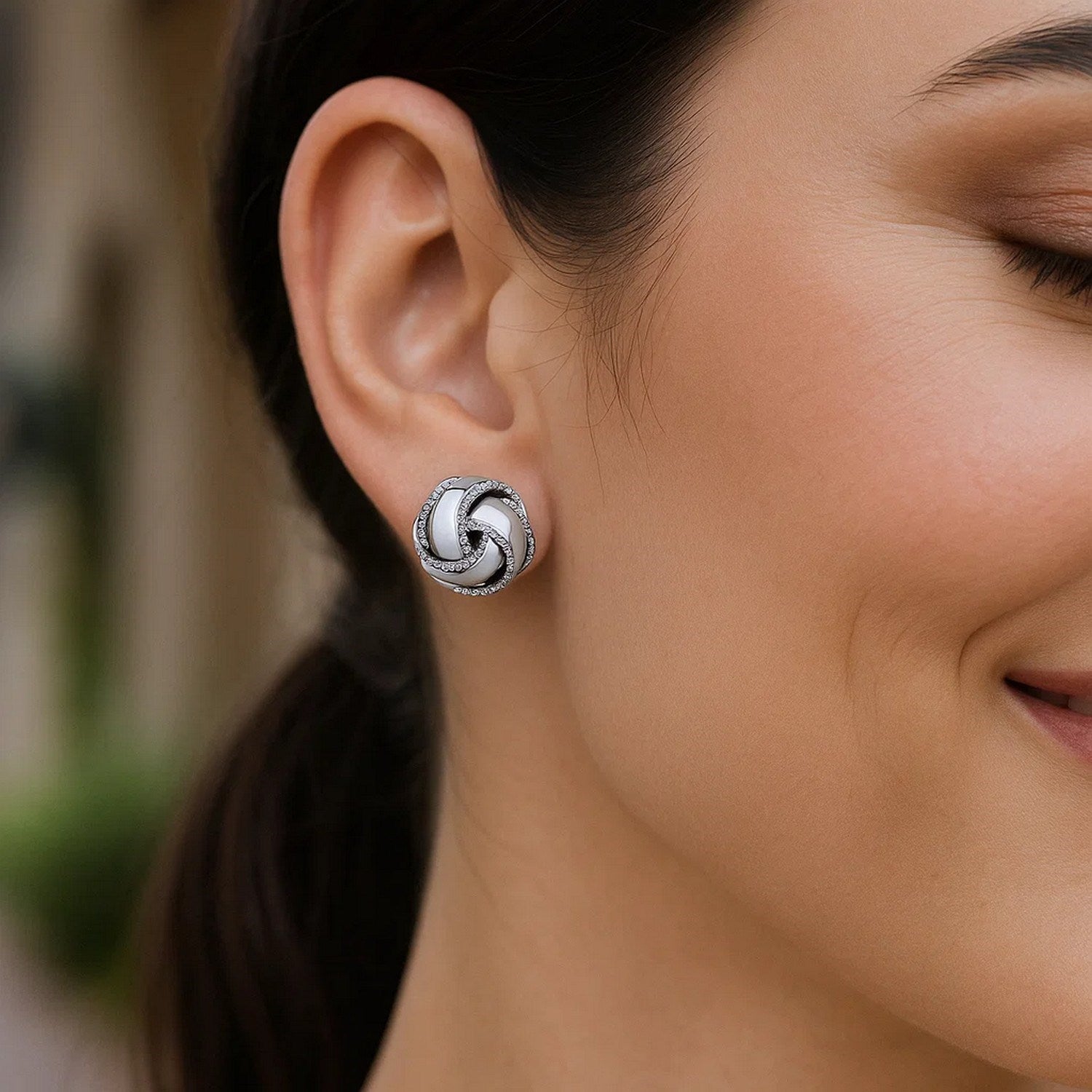 Sterling silver love knot earrings with textured and polished details.