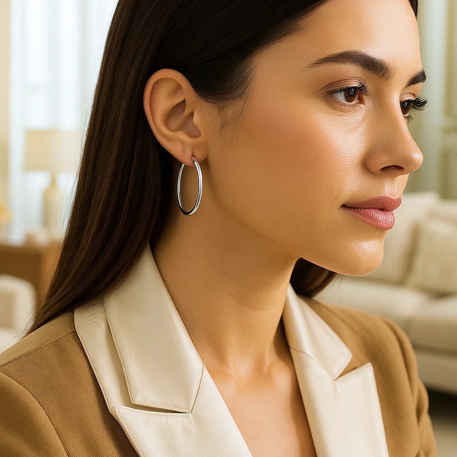 Sterling silver rhodium plated polished hoop earrings on a woman's ear.
