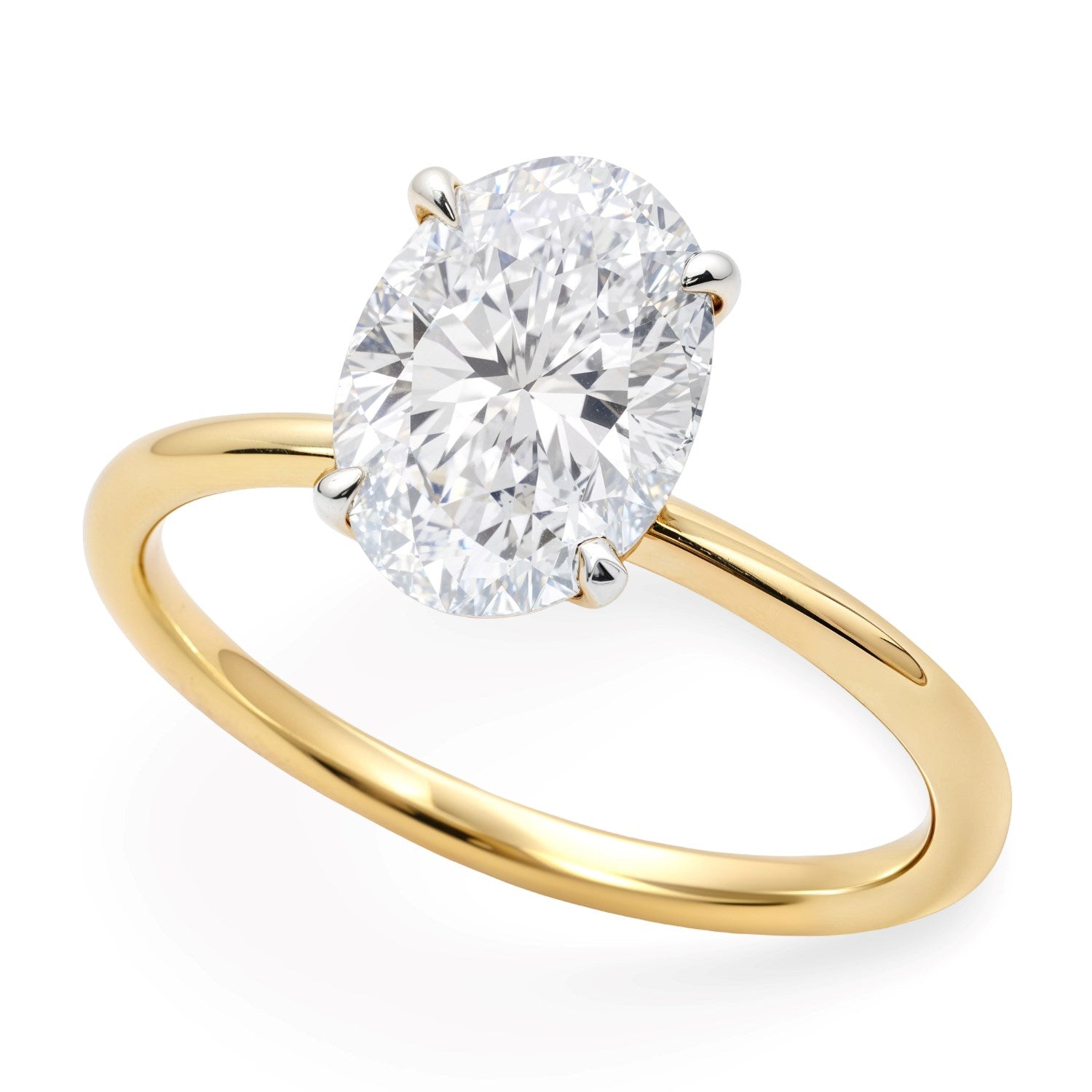 An oval lab-grown diamond solitaire ring with a yellow gold band and white gold prongs.