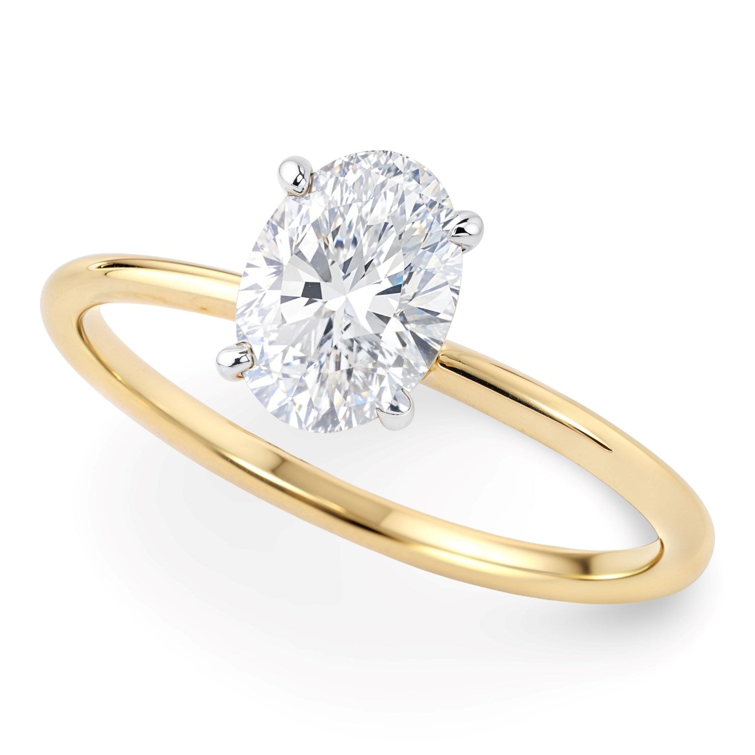 An oval lab-grown diamond solitaire ring with a yellow gold band and white gold prongs.