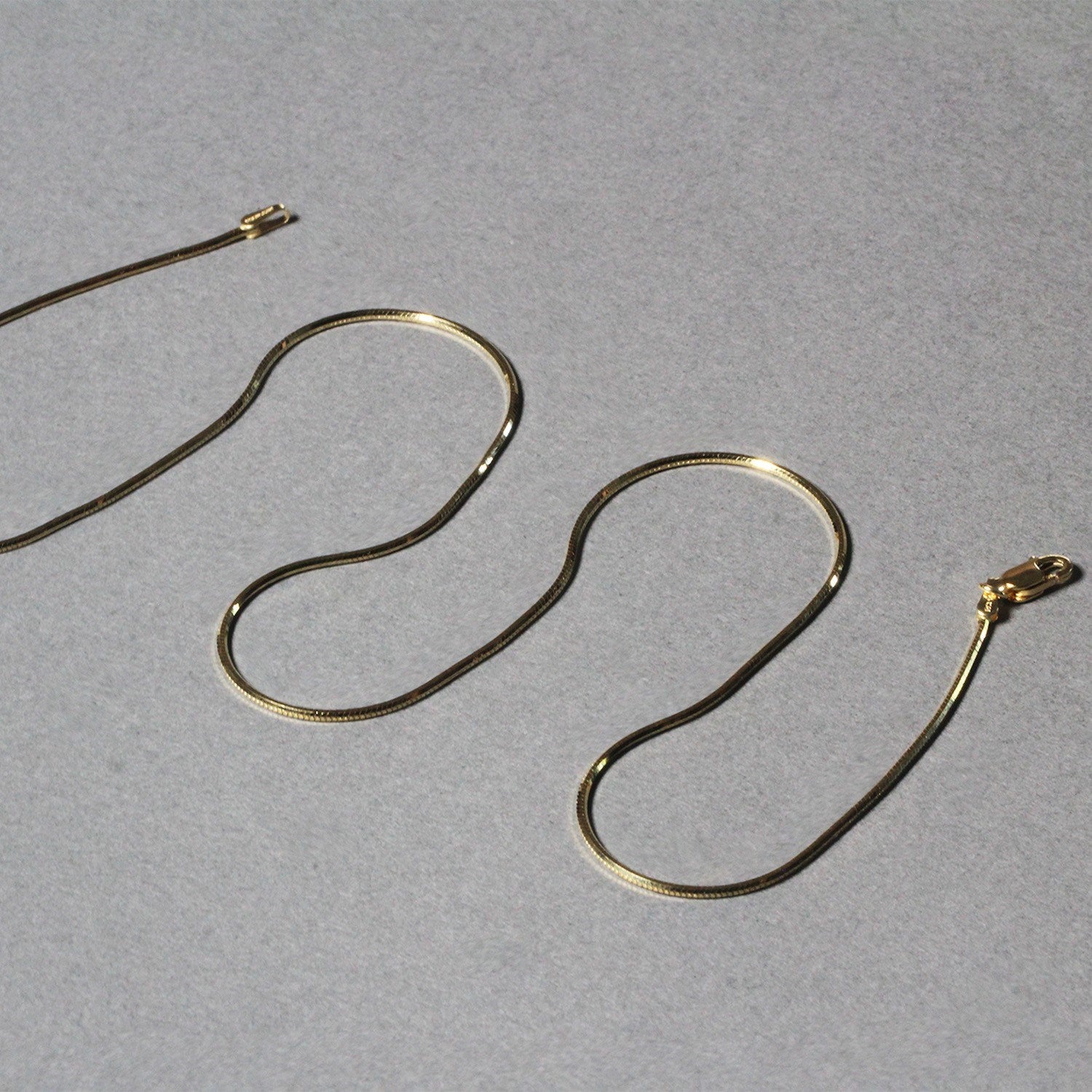 A shiny 14K yellow gold octagonal snake chain with a lobster clasp.