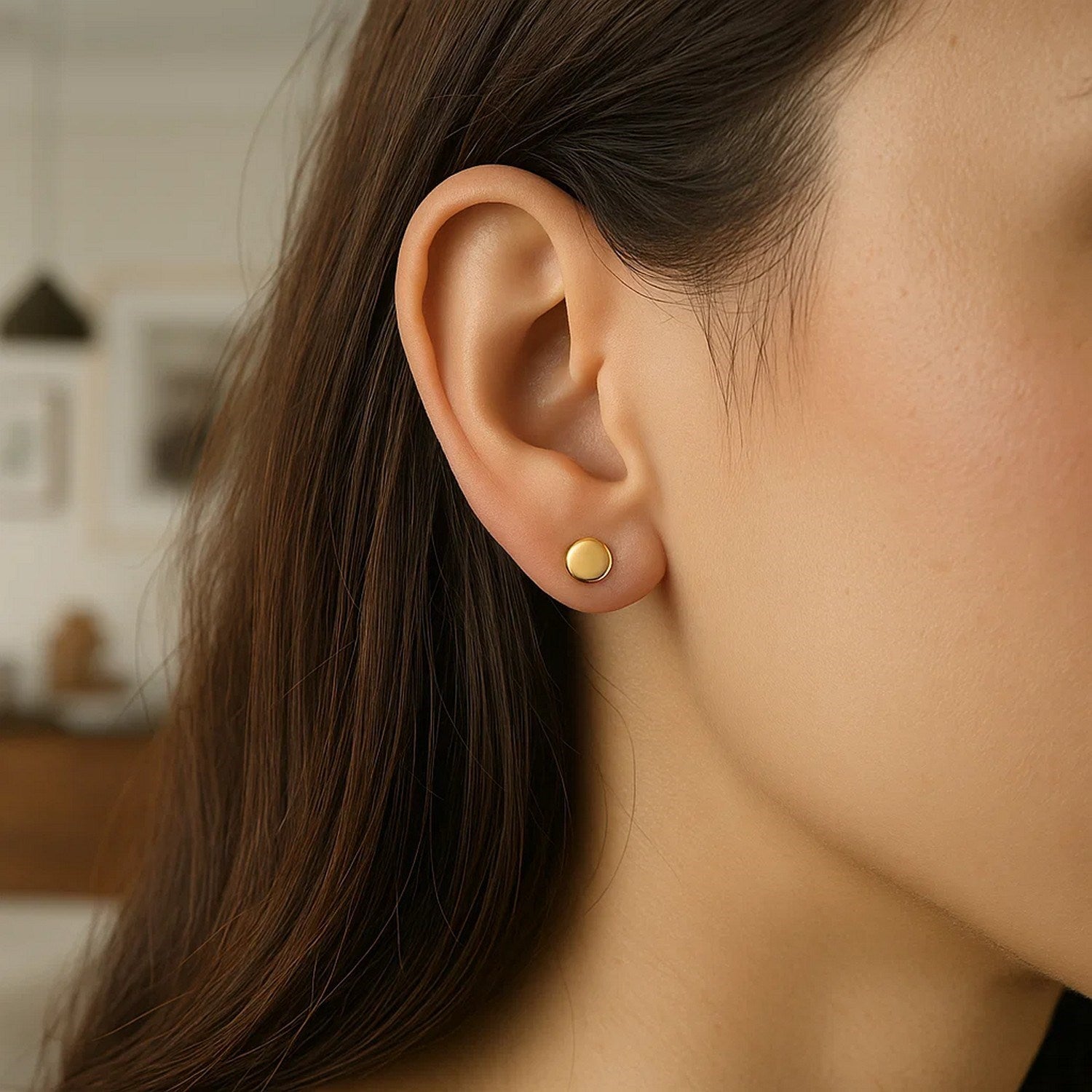 14k yellow gold polished round post earrings on a woman's ear.