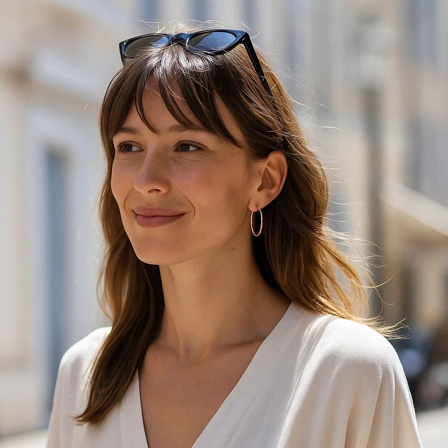10k yellow gold polished hoop earrings on a woman with brown hair.