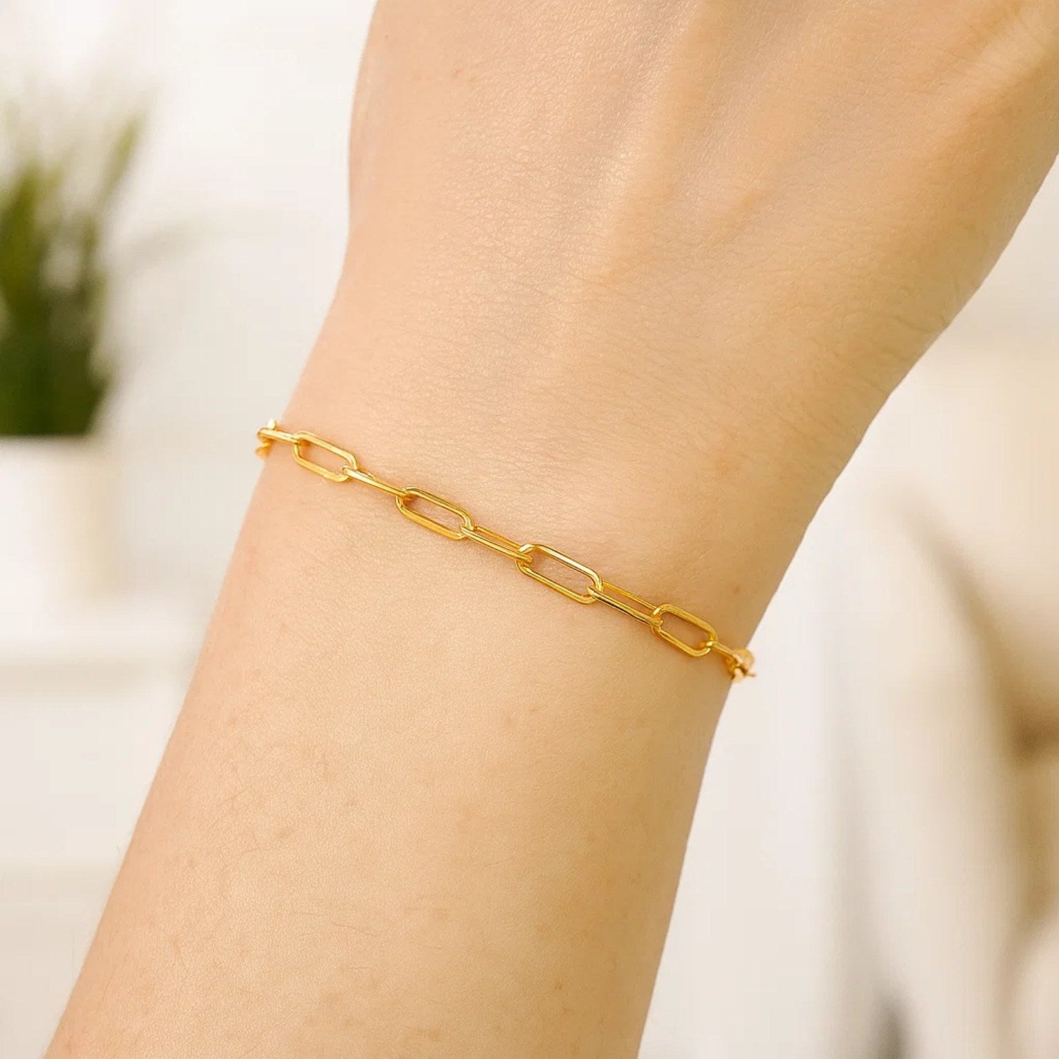 A 14K yellow gold paperclip bracelet with 3.5mm wide links on a person's wrist.