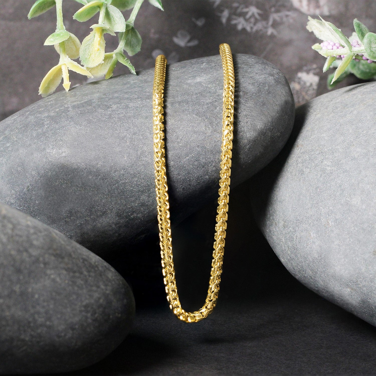 14k yellow gold diamond cut round Franco chain (2.70 mm) on grey stones.