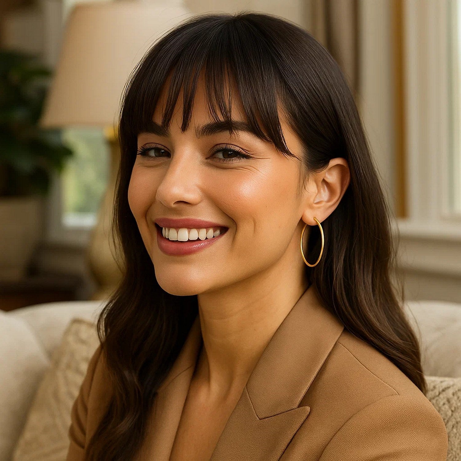 A woman wears 14K yellow gold endless hoop earrings.