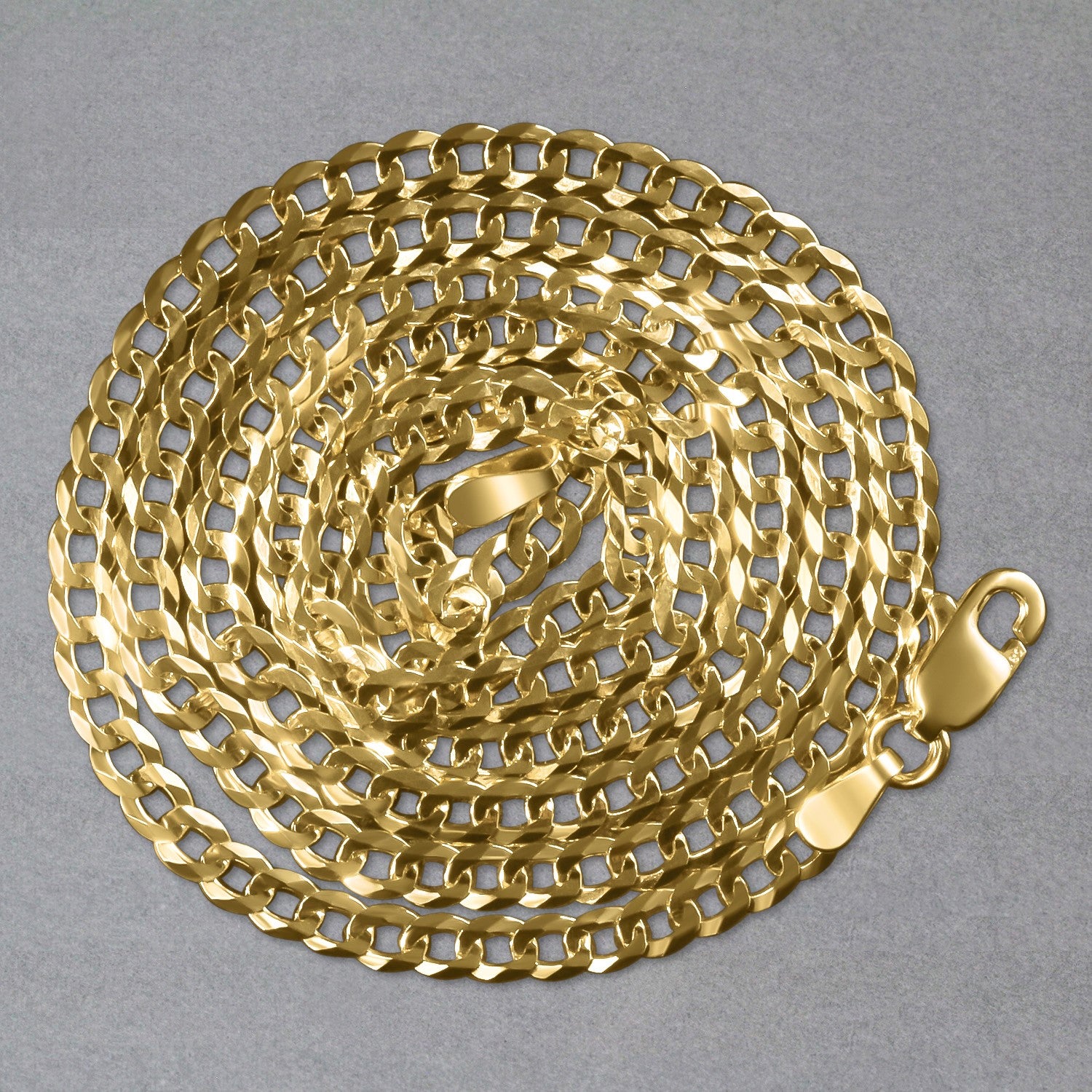 14k yellow gold solid curb chain, coiled on a gray background, with a lobster clasp visible.