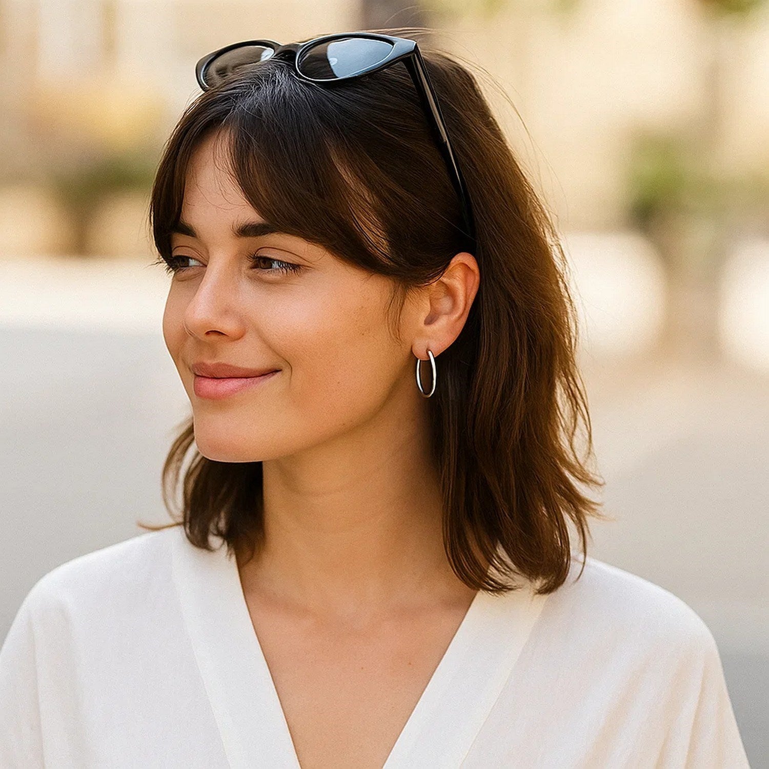 10k white gold polished hoop earrings on a woman with dark hair and a white top.