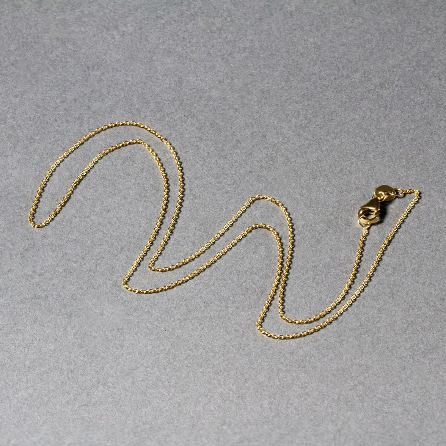 An 18k yellow gold round cable link chain with a lobster clasp.