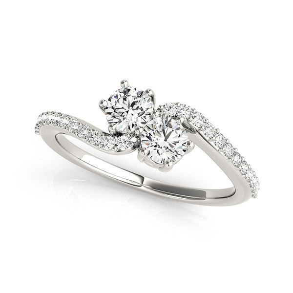 A curved 14k white gold ring with two large diamonds and pavé side diamonds.