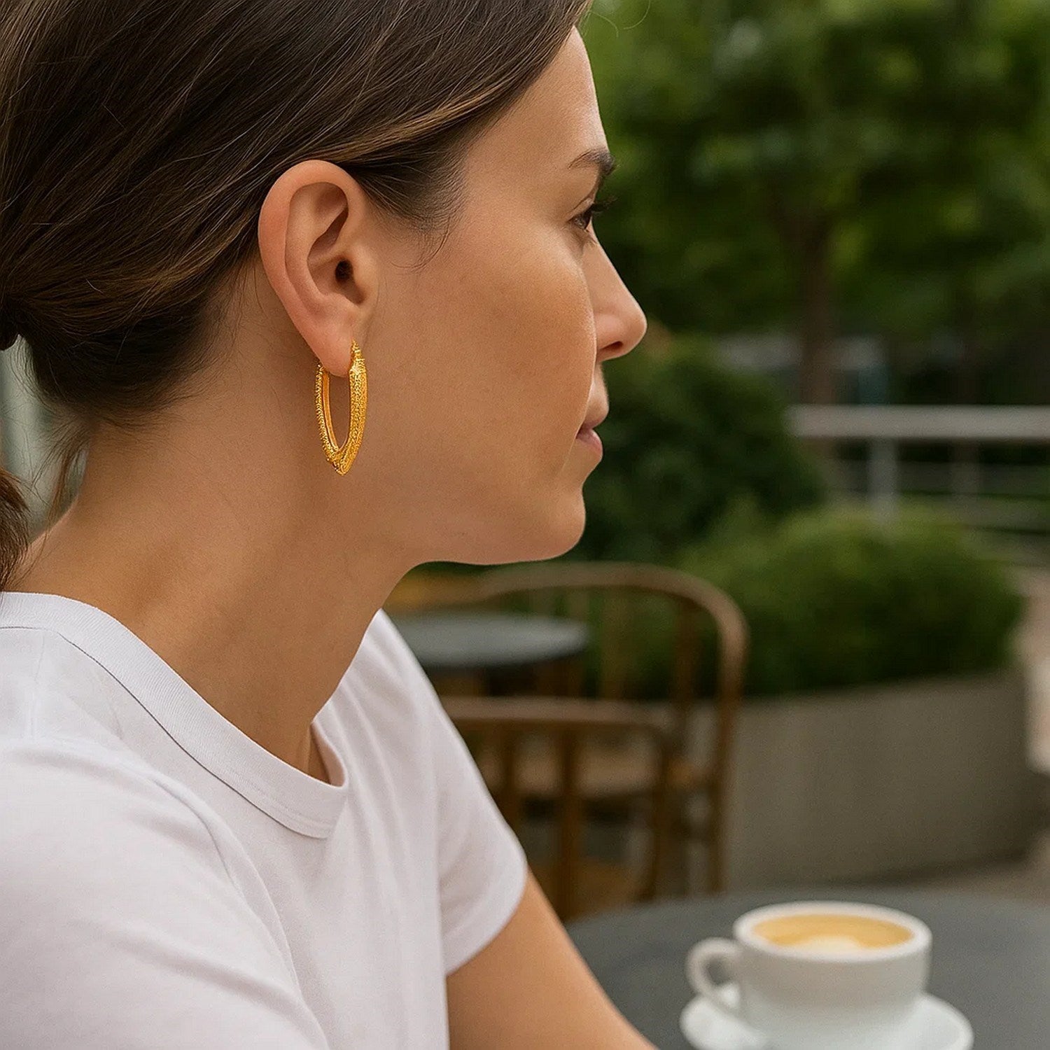 14k yellow gold V-shaped puffed hoop earrings with a textured finish.