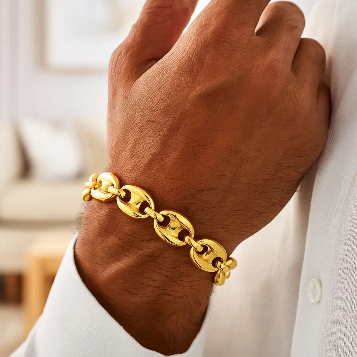 A man's arm wearing a 14k yellow gold high polish lite puffed mariner link bracelet.