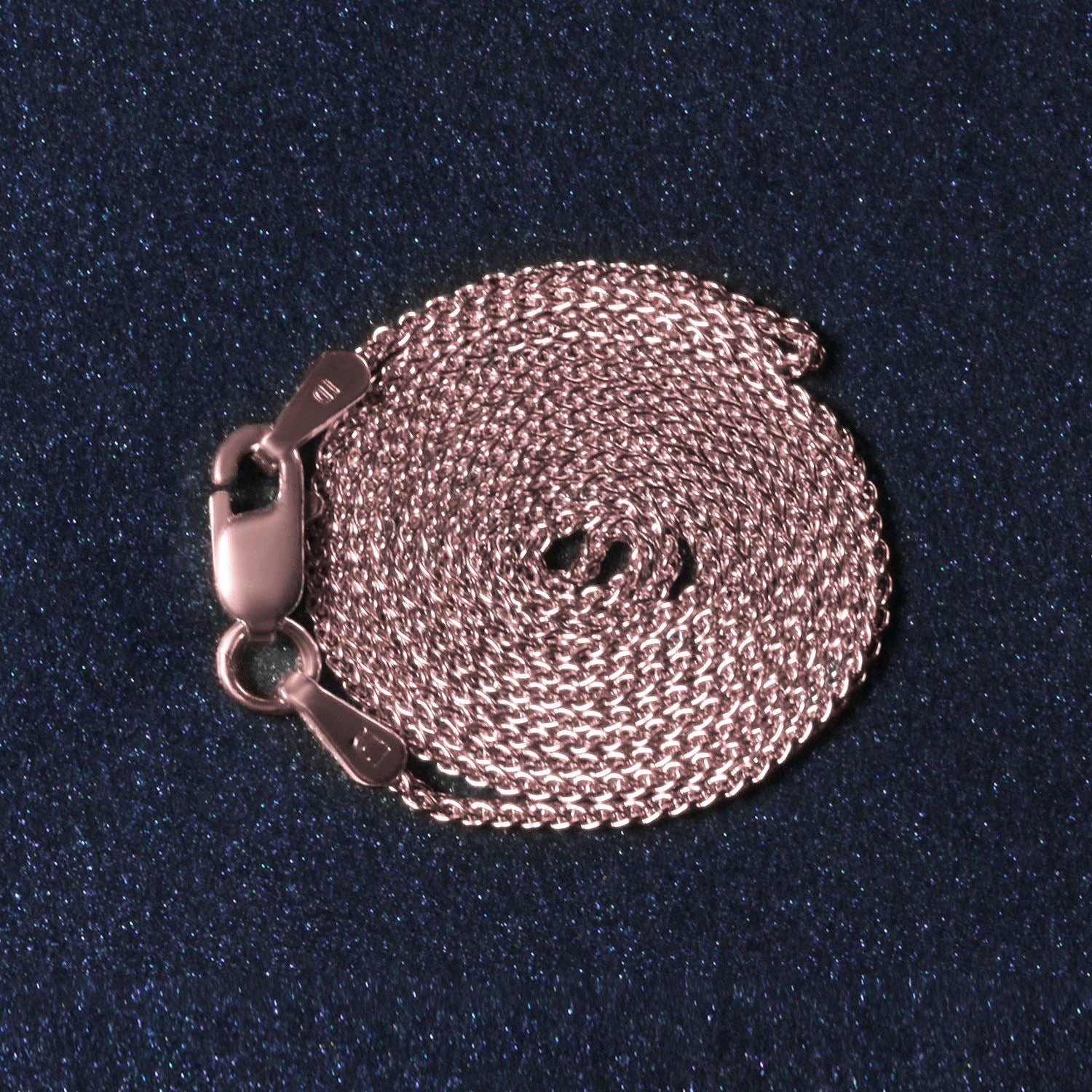 A coiled 14k rose gold round wheat chain with a lobster clasp.