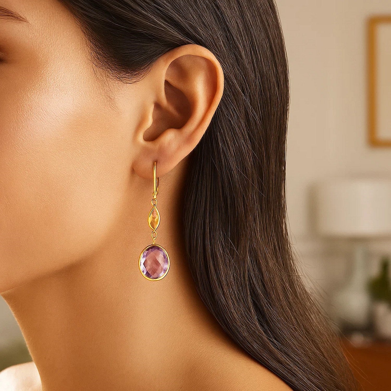 14k yellow gold drop earrings with citrine and amethyst briolettes on a woman's ear.