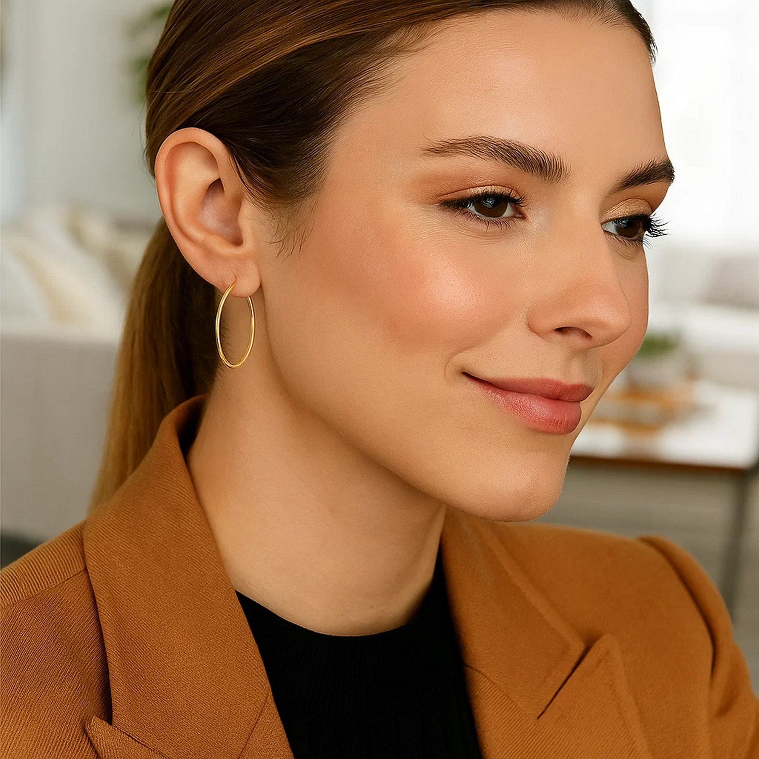 10k yellow gold polished hoop earrings on a woman.