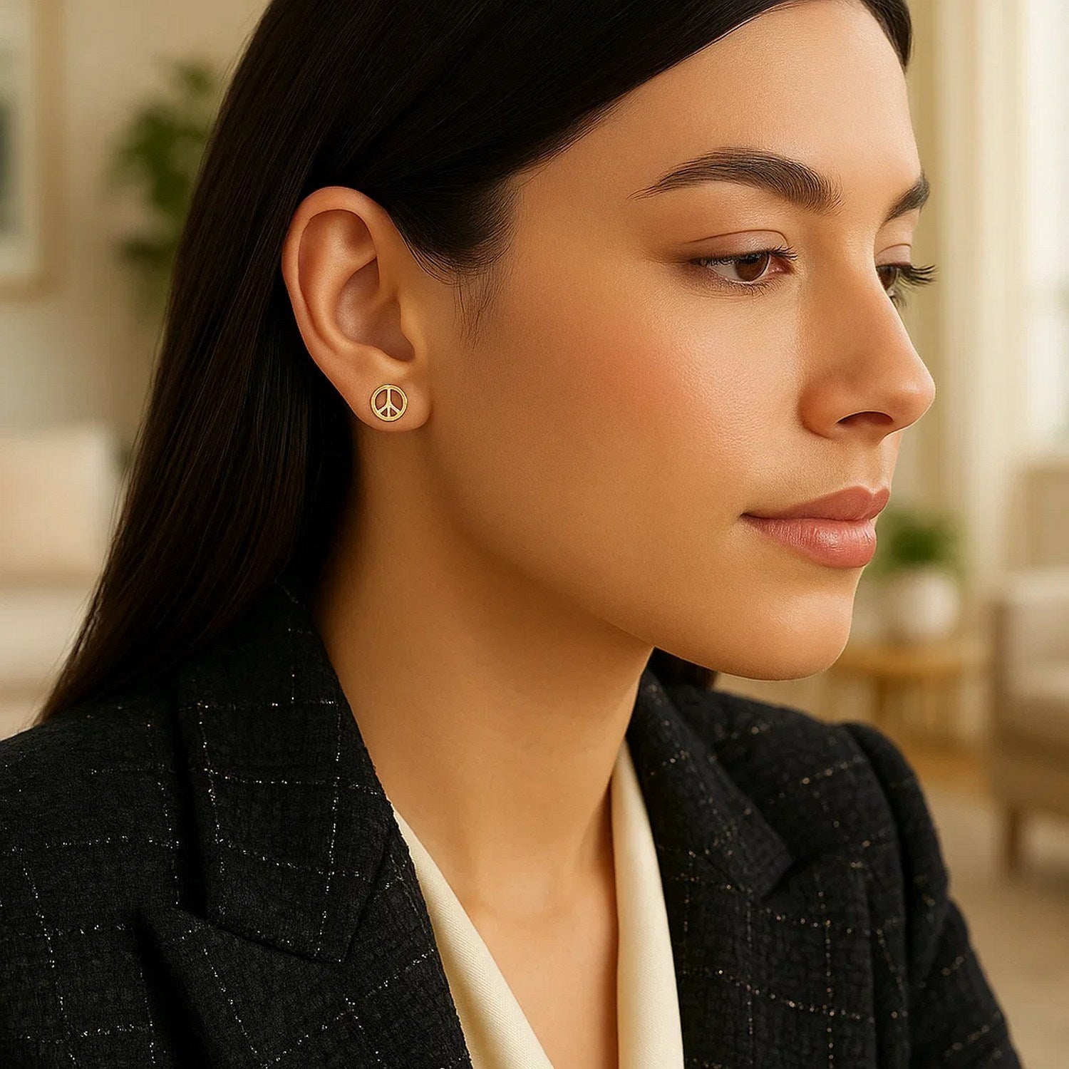 14k yellow gold peace sign post earrings on a woman's ear.