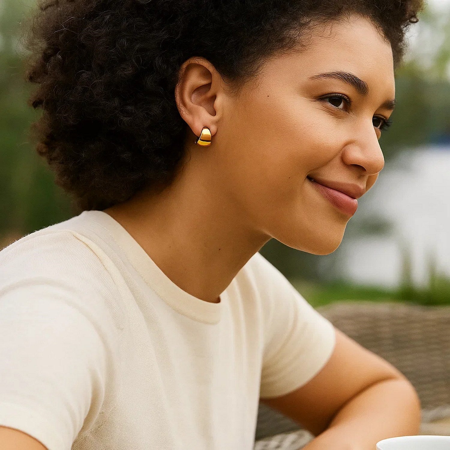 Puffed Up Graduated Hoop Earrings in 14K Yellow Gold on a woman.