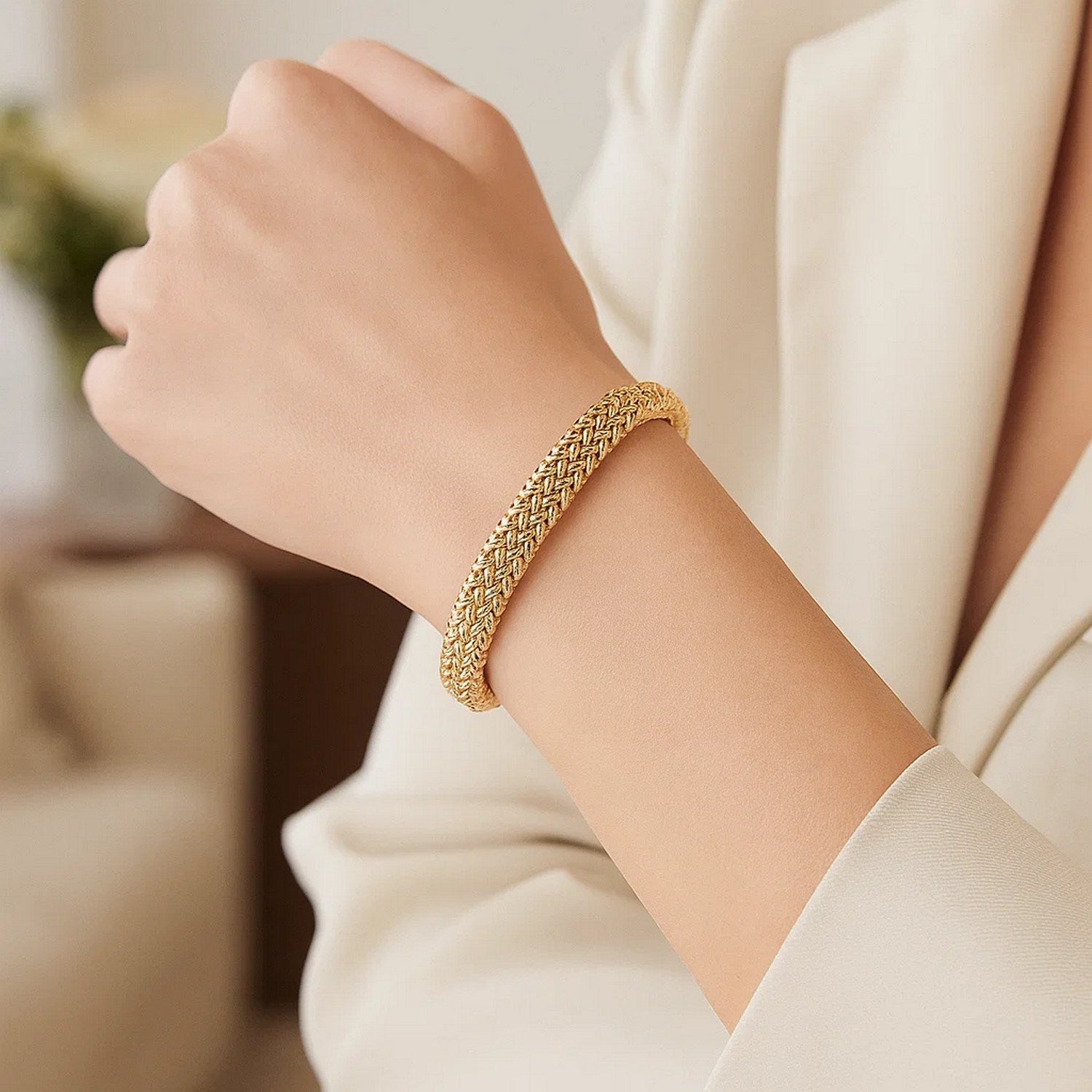 14k yellow gold high polish thick braided bracelet on a person's wrist.