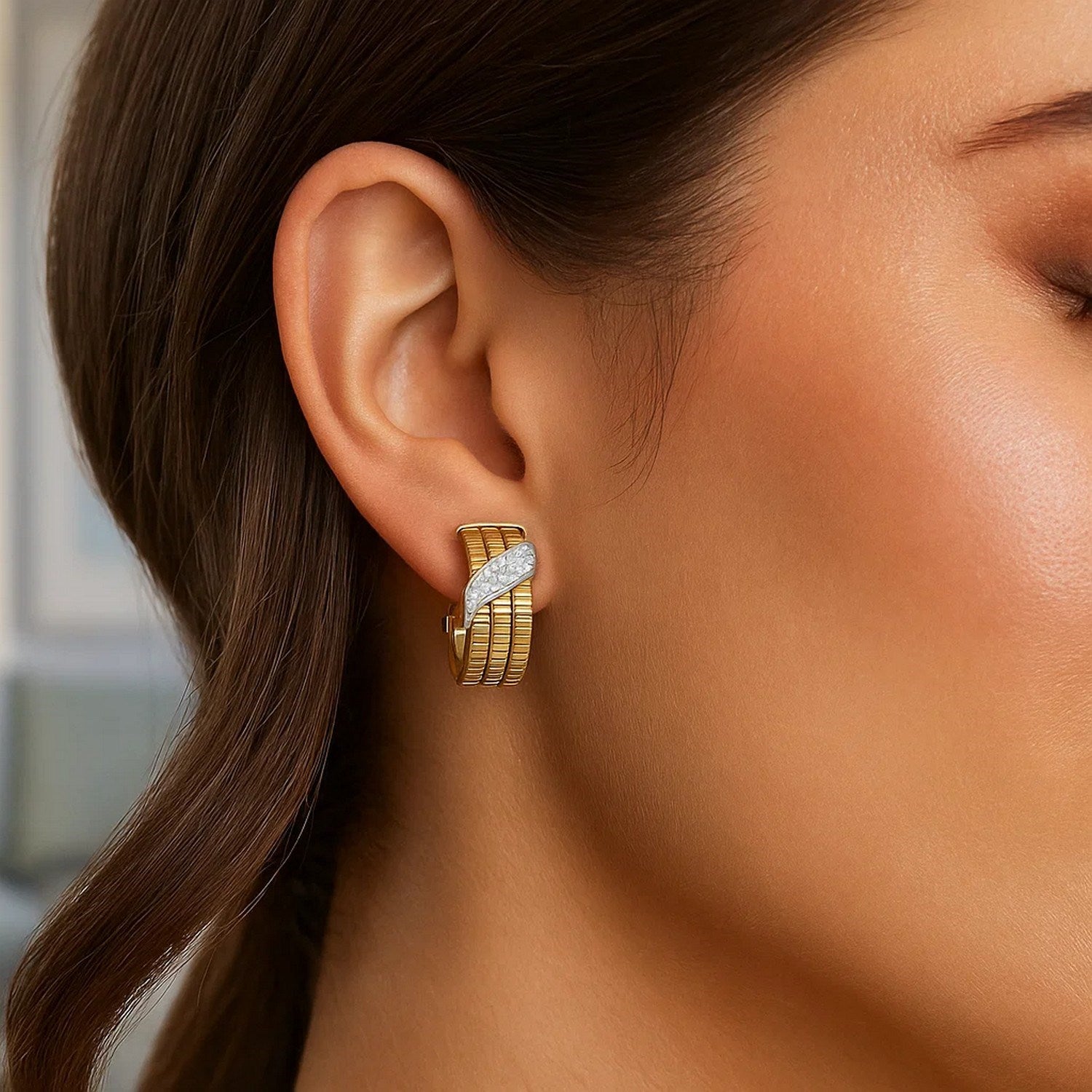 14K yellow gold triple row diamond omega hoop earrings on a model's ear.