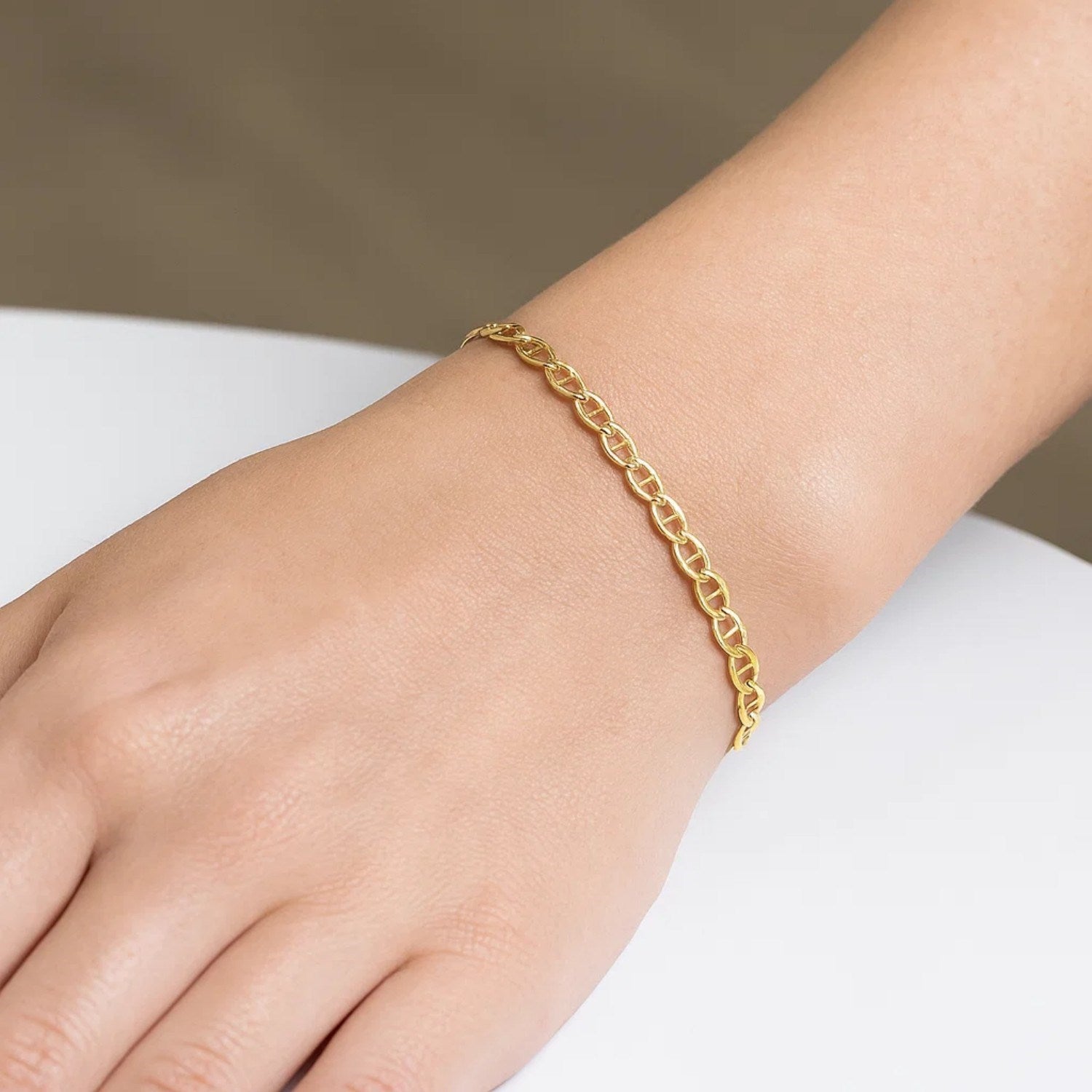 A 10k yellow gold mariner link bracelet is worn on a person's wrist.