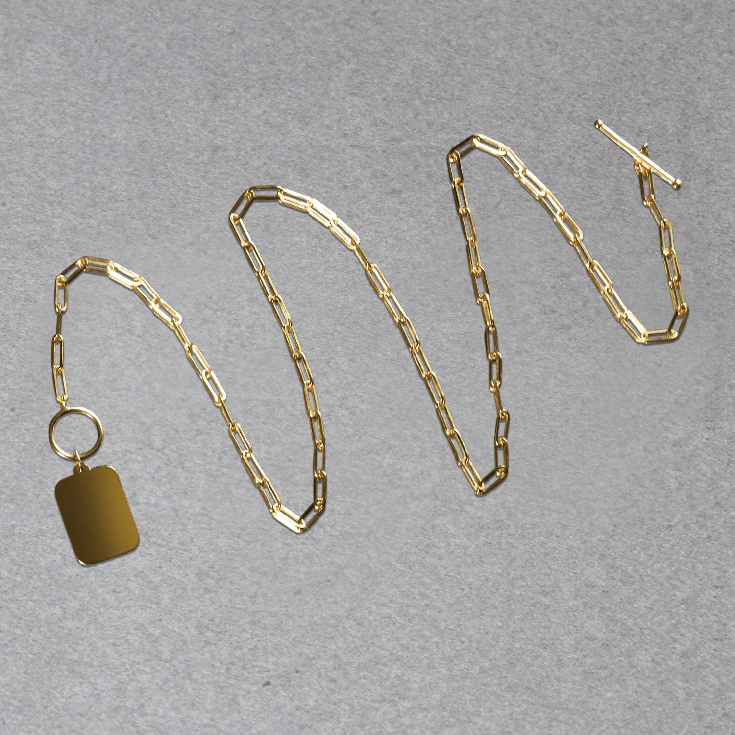14k yellow gold paperclip chain necklace with a rounded rectangle pendant and toggle clasp.