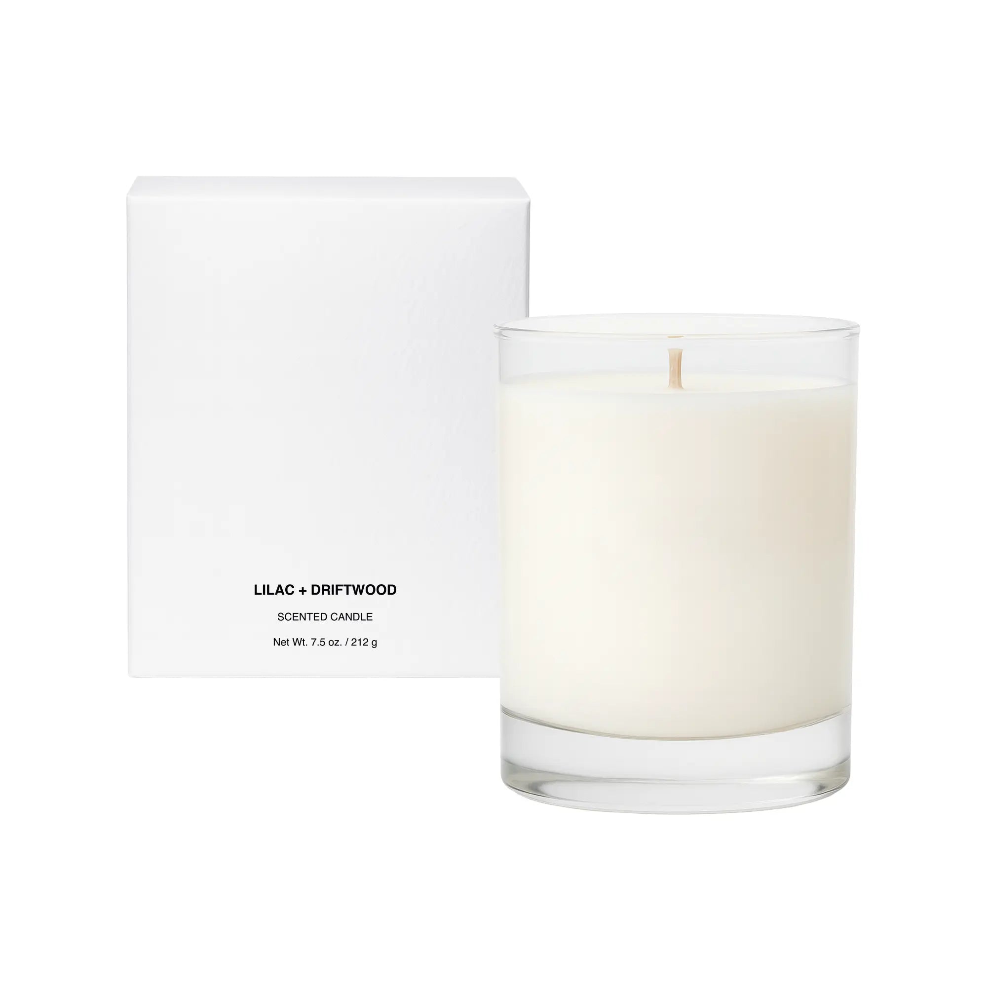 A white box and a clear glass candle with a wooden wick, labeled "Lilac + Driftwood."